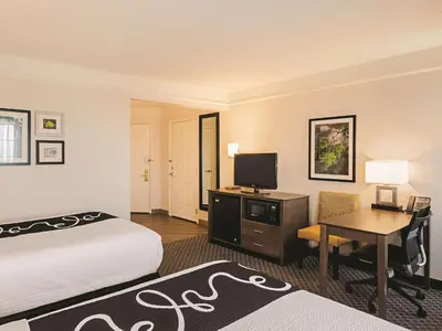 a hotel room with a bed and a desk with a television at La Quinta by Wyndham Denver Tech Center in Greenwood Village