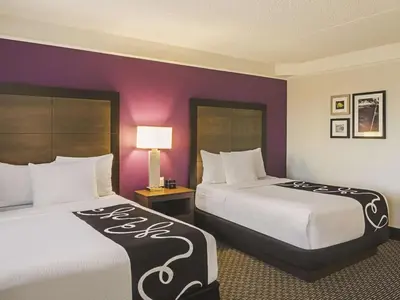 two beds in a hotel room with purple walls at La Quinta by Wyndham Denver Tech Center in Greenwood Village