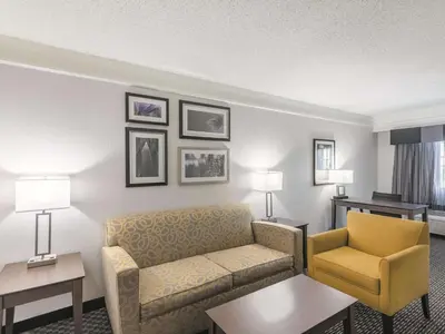 a hotel room with a couch and a chair at La Quinta by Wyndham Denver Tech Center in Greenwood Village