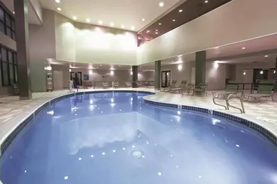 a large pool in a hotel with chairs and tables at La Quinta by Wyndham Denver Englewood Tech Ctr in Greenwood Village