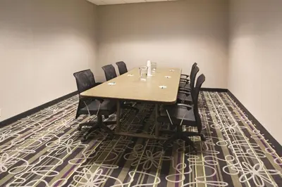 a conference room with a wooden table and black chairs at La Quinta by Wyndham Denver Englewood Tech Ctr in Greenwood Village