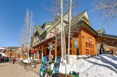 a ski lodge with skis parked outside of it at 1 Bedroom Colorado Vacation Rental In River Run Village Steps From The River Run Gondola in Keystone