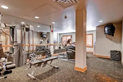a gym with treadmills and machines in a room at 1 Bedroom Colorado Vacation Rental In River Run Village Steps From The River Run Gondola in Keystone