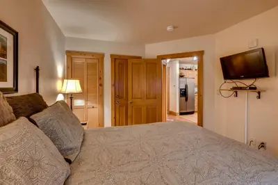 a bedroom with a bed and a tv on the wall at 2 Bedroom Colorado Vacation Rental In River Run Village With Pool And Hot Tub Access in Keystone