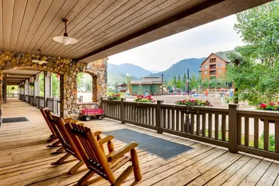 a deck with chairs and a view of the mountains at 2 Bedroom Colorado Vacation Rental In River Run Village With Pool And Hot Tub Access in Keystone