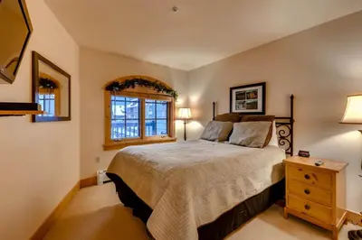 a bedroom with a large bed and two windows at 2 Bedroom Colorado Vacation Rental In River Run Village With Pool And Hot Tub Access in Keystone