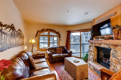 a living room with leather furniture and a fireplace at 2 Bedroom Colorado Vacation Rental In River Run Village With Pool And Hot Tub Access in Keystone