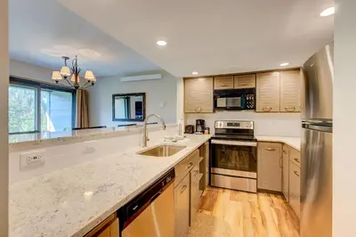 a kitchen with wooden cabinets and stainless steel appliances at Frostfire E41 Condo in Keystone
