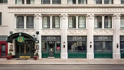 a large white building with green doors on a street at Kimpton Hotel Monaco Denver by IHG in Denver