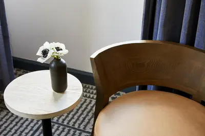 a vase with flowers on a table next to a chair at Kimpton Hotel Monaco Denver by IHG in Denver