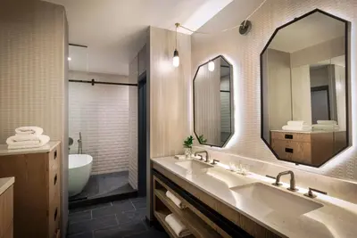 a bathroom with two sinks and a tub and a mirror at Kimpton Hotel Monaco Denver by IHG in Denver