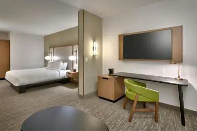 a hotel room with a bed and a desk with a television at Fairfield Inn & Suites by Marriott Denver West/Federal Center in Lakewood