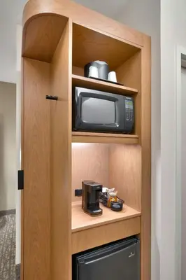 a kitchen with a microwave and a coffee maker in a cabinet at Fairfield Inn & Suites by Marriott Denver West/Federal Center in Lakewood