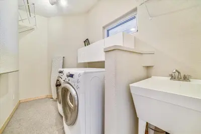a laundry room with a washing machine and a sink at Larson Lane 217 Home in Frisco