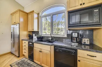 a kitchen with wooden cabinets and a sink and a window at Larson Lane 217 Home in Frisco