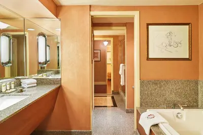 a bathroom with a tub and a sink and a mirror at The Brown Palace Hotel and Spa, Autograph Collection in Denver