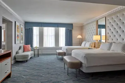 a large hotel room with two beds and a chair at The Brown Palace Hotel and Spa, Autograph Collection in Denver