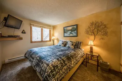 a bedroom with a bed and a tv on the wall at Iron Horse Building C Unit 1023 in Winter Park