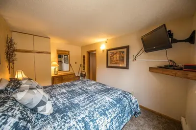 a bedroom with a bed and a flat screen tv at Iron Horse Building C Unit 1023 in Winter Park