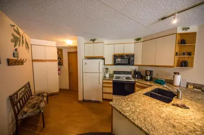a kitchen with a white refrigerator and a counter top at Iron Horse Building C Unit 1023 in Winter Park