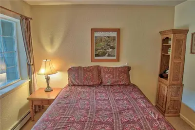 a bedroom with a bed and a table with a lamp at Villas at Swan's Nest #701 (Condo) in Gold Hill