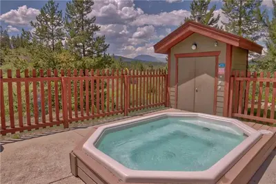a hot tub in a backyard with a dog house at Villas at Swan's Nest #701 (Condo) in Gold Hill
