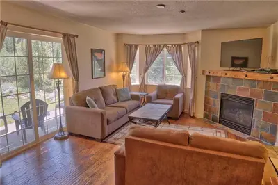 a living room with a couch and a fireplace at Villas at Swan's Nest #701 (Condo) in Gold Hill