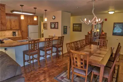 a kitchen and dining room with a wooden table and chairs at Villas at Swan's Nest #701 (Condo) in Gold Hill
