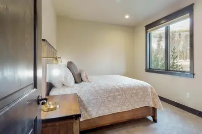 a bedroom with a bed with a table and a window at Ogren Overlook in Keystone
