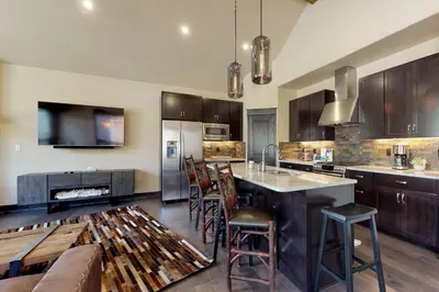 a kitchen with wooden cabinets and a kitchen island with bar stools at Ogren Overlook in Keystone