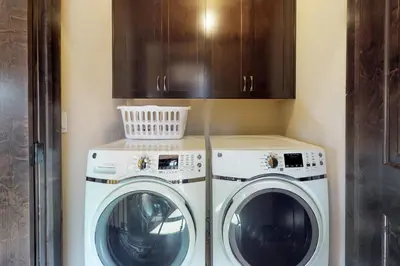 two washing machines and cabinets in a laundry room at Ogren Overlook in Keystone