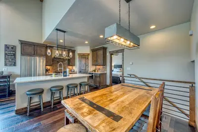 a kitchen with a wooden table and a bar at 2nd Ave Luxury in Frisco
