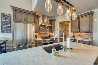 a kitchen with a sink and a refrigerator at 2nd Ave Luxury in Frisco
