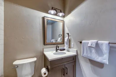a bathroom with a sink and a toilet and a mirror at 2nd Ave Luxury in Frisco