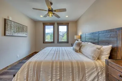 a bedroom with a large bed with a ceiling fan at 2nd Ave Luxury in Frisco