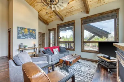 a living room with couches and a flat screen tv at 2nd Ave Luxury in Frisco