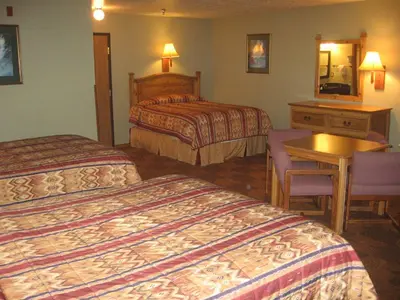 a hotel room with two beds and a table at New Summit Inn in Frisco