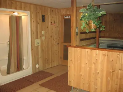 a room with wooden walls and a bathroom with a shower at New Summit Inn in Frisco