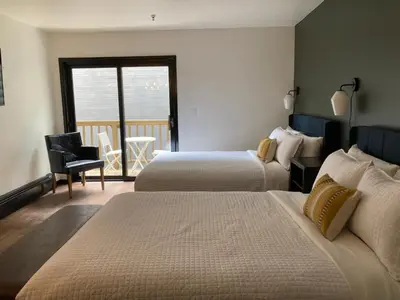 a hotel room with two beds and a balcony at Hotel Frisco in Frisco