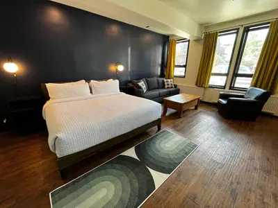 a bedroom with a bed and a living room with a couch at Hotel Frisco in Frisco