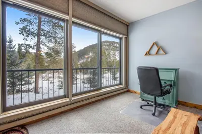 an office with a desk and a chair in a room with windows at Pines Foxtail 2046 in Keystone