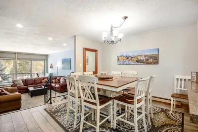 a dining room and living room with a table and chairs at Pines Foxtail 2046 in Keystone