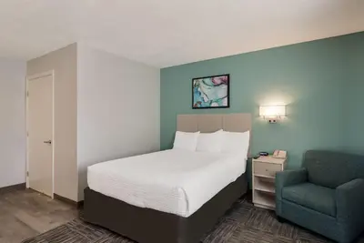 a bedroom with a bed and a chair in it at MainStay Suites Denver Tech Center in Centennial