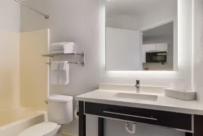 a bathroom with a sink and a toilet and a mirror at MainStay Suites Denver Tech Center in Centennial