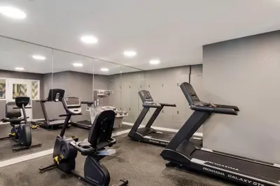 a gym with treadmills and ellipticals in front of a mirror at MainStay Suites Denver Tech Center in Centennial
