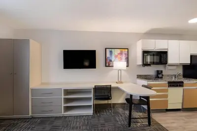 a kitchen with a desk and a table at MainStay Suites Denver Tech Center in Centennial