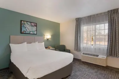 a hotel room with a large bed and a window at MainStay Suites Denver Tech Center in Centennial