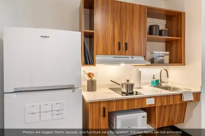 a kitchen with a refrigerator and a microwave at Uptown Suites Extended Stay Denver CO -Westminster in Westminster