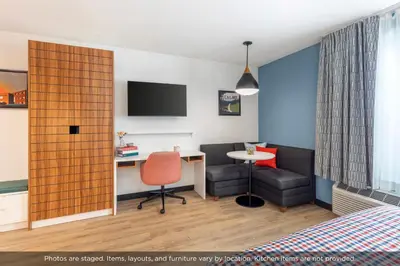 a hotel room with a bed and a desk and a chair at Uptown Suites Extended Stay Denver CO -Westminster in Westminster