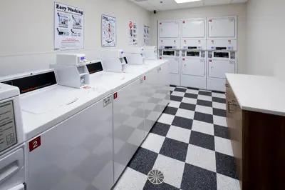 a kitchen with white cabinets and a checkered floor at Uptown Suites Extended Stay Denver CO -Westminster in Westminster